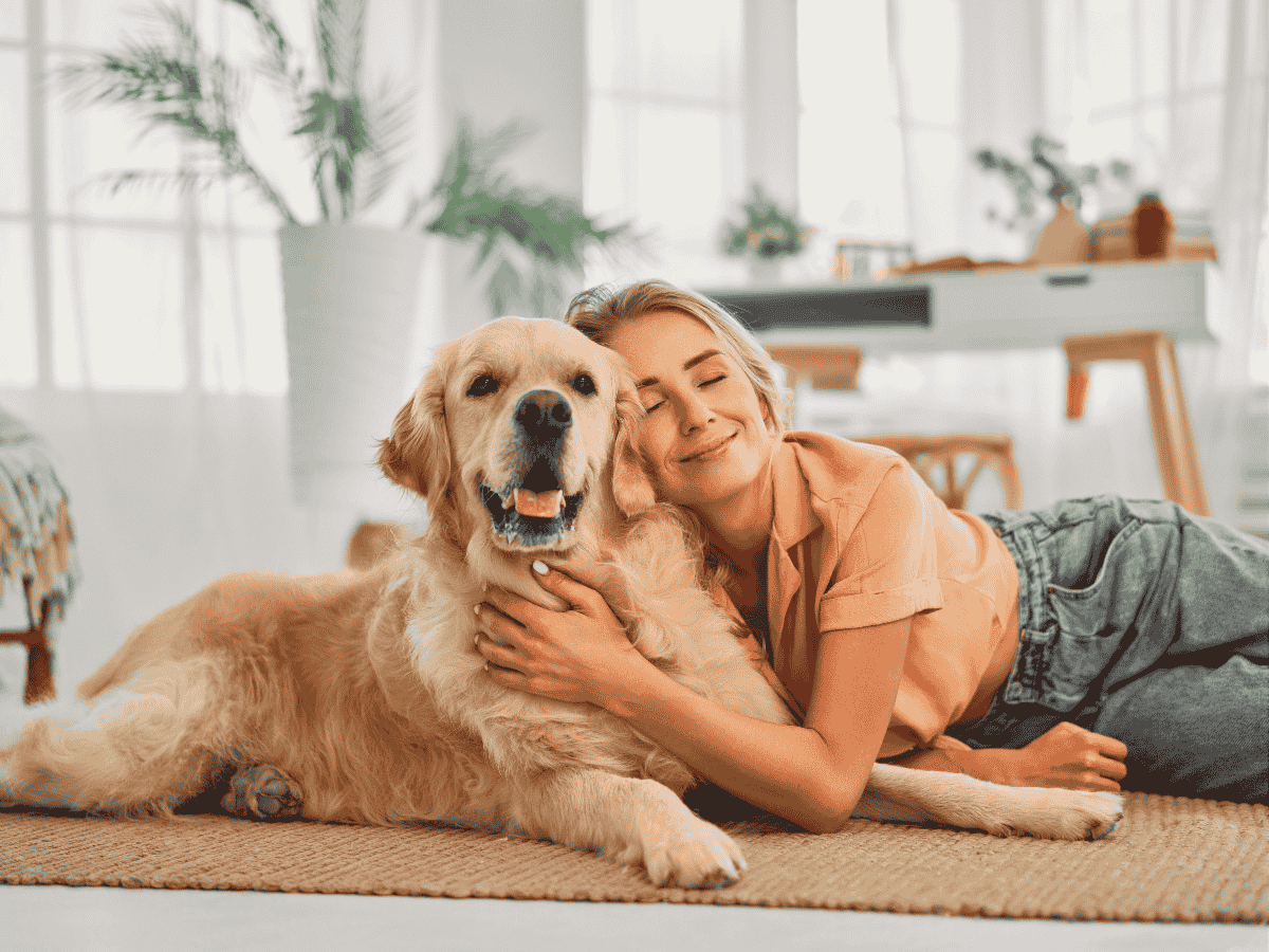 owner cuddling dog on floor